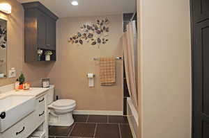 Full bathroom featuring vanity, tile patterned flooring, toilet, and shower / bathtub combination with curtain