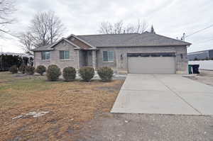 Single story home with a garage and a front yard