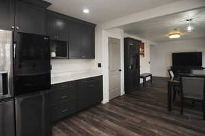 Kitchen with pendant lighting, refrigerator with ice dispenser, and dark wood-type flooring