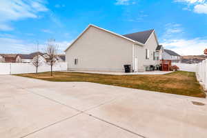 View of side of home featuring a patio area and a lawn