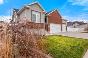 View of front of house featuring a garage and a front yard