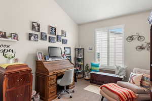 Carpeted office featuring vaulted ceiling