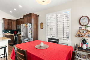 Dining area featuring wood-style flooring and lofted ceiling