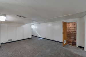 Basement featuring dark colored carpet