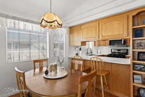 Dining room with lofted ceiling, a chandelier, and sink