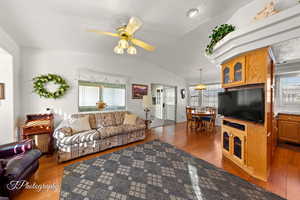 Living room with lofted ceiling, hardwood / wood-style floors, and ceiling fan