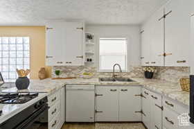 Kitchen with white cabinets, range with gas cooktop, and dishwasher