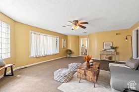 Carpeted living room with ceiling fan