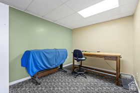 Miscellaneous room featuring dark carpet and a drop ceiling