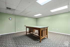 Recreation room featuring carpet floors and a paneled ceiling