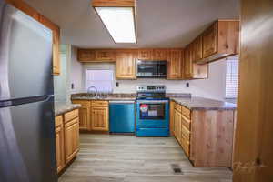 Kitchen featuring stainless steel appliances, sink, and light hardwood / wood-style floors