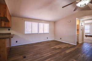 living room with vaulted ceiling, dark hardwood / wood-style floors, and ceiling fan