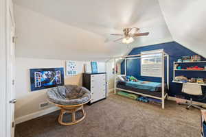 Bedroom with vaulted ceiling, ceiling fan, and carpet flooring