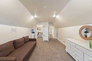 Living room with carpet flooring and vaulted ceiling