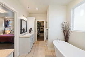 Bathroom with vanity, a tub to relax in, and tile patterned floors