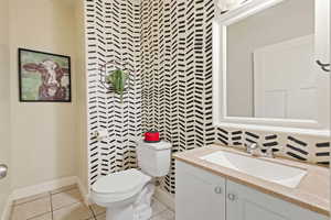 Bathroom featuring vanity, tile patterned floors, and toilet