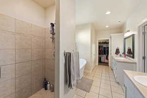 Bathroom featuring tile patterned floors, vanity, and plus walk in shower