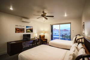 Carpeted bedroom with a wall mounted air conditioner, ceiling fan, and access to exterior