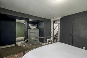 Carpeted bedroom with a textured ceiling