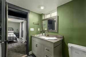 Bathroom featuring vanity, toilet, and a textured ceiling