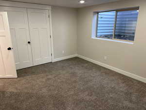 Unfurnished bedroom with dark carpet and a closet