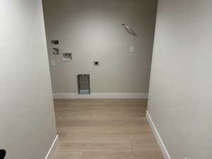 Washroom with washer hookup, hookup for an electric dryer, and light hardwood / wood-style floors