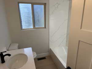 Full bathroom with hardwood / wood-style flooring, vanity, toilet, and tub / shower combination