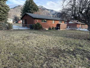 Exterior space featuring a mountain view, a yard, and central air condition unit