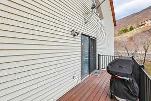 Wooden deck featuring a mountain view and area for grilling