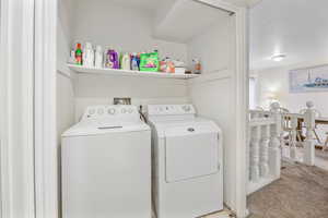 Clothes washing area with separate washer and dryer and carpet floors