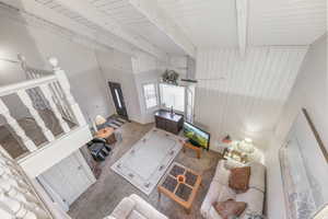 Living room featuring beam ceiling, wood walls, and carpet