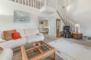 Living room with light colored carpet and a high ceiling