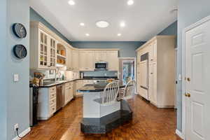 Kitchen featuring a breakfast bar area, a center island, dark stone counters, stainless steel appliances, and cream cabinetry