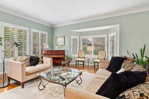 Living room featuring crown molding and light hardwood / wood-style floors