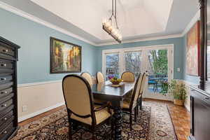 Dining area with light parquet floors, ornamental molding, and french doors