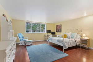 Bedroom with dark hardwood / wood-style flooring