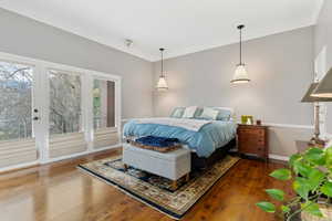 Bedroom featuring dark wood-type flooring, access to outside, and ornamental molding