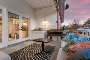 Patio terrace at dusk with french doors, grilling area, and an outdoor hangout area