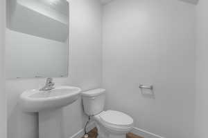 Bathroom featuring wood-type flooring, toilet, and sink