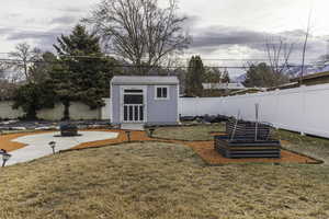 View of yard featuring a storage shed and an outdoor fire pit