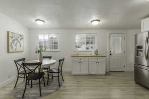 Dining space featuring light hardwood / wood-style floors and a textured ceiling