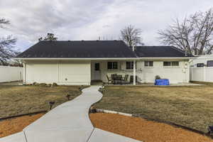 Back of property with a lawn and a patio