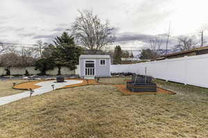 View of yard with a fire pit and a storage unit