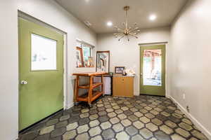 Doorway with a notable chandelier