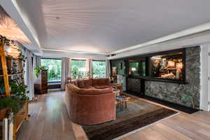 Living room with hardwood / wood-style flooring and vaulted ceiling