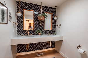 Bathroom featuring double sink and hardwood / wood-style floors