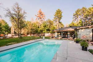 View of swimming pool featuring a patio, an outbuilding, and a lawn