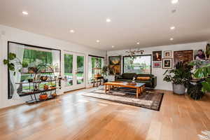 Living room with light hardwood / wood-style flooring and french doors