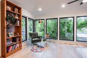 Sitting room with ceiling fan and light wood-type flooring