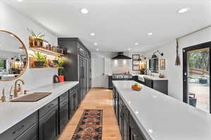 Kitchen featuring sink, plenty of natural light, wall chimney exhaust hood, and light wood-type flooring